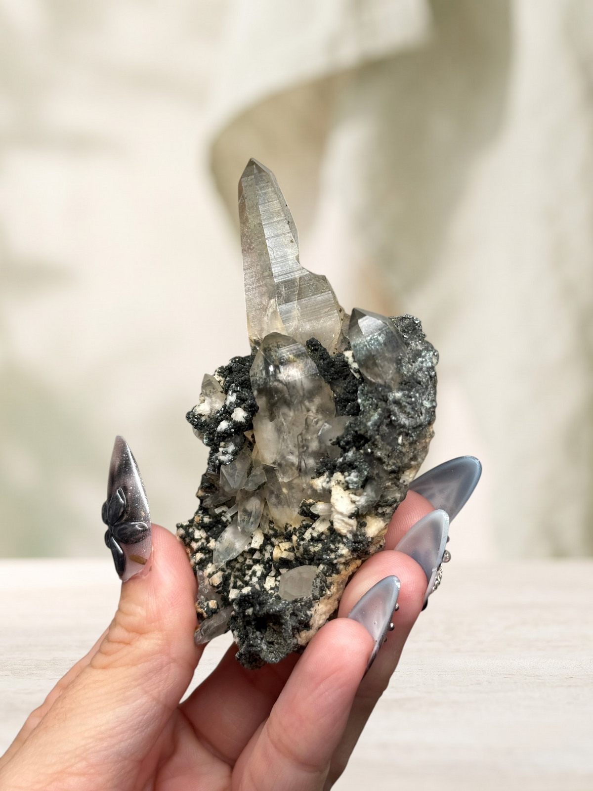 Crystal Glade natural laser quartz specimen from Balochistan, Pakistan, held in hand showing slender tapering crystals.