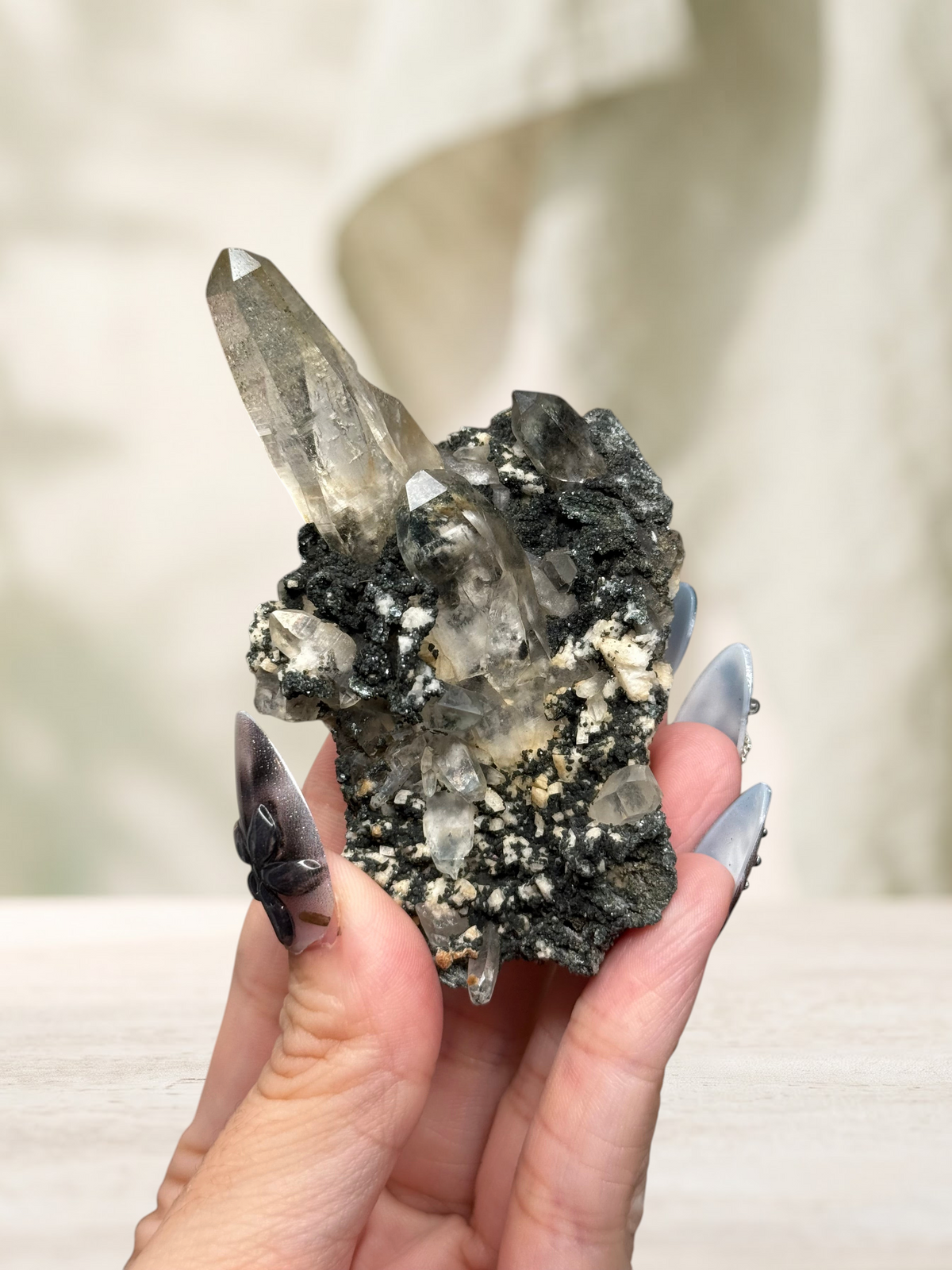 Crystal Glade laser quartz specimen from Pakistan featuring a long, slender, clear crystal point on a dark matrix.